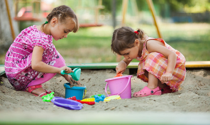 två flickor leker i sandlådan