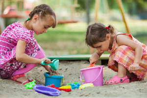 två flickor leker i sandlådan