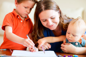 Young mother and her two kids drawing together