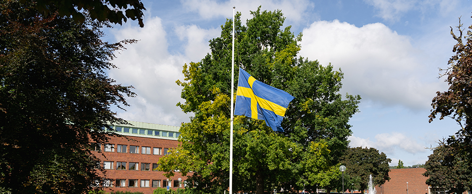 Svenska flaggan på halv stång framför Stadshuset i Falköping.